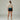 Femme de dos portant un t-shirt beige et un short de sport noir avec une ceinture bleu turquoise NaRsKo